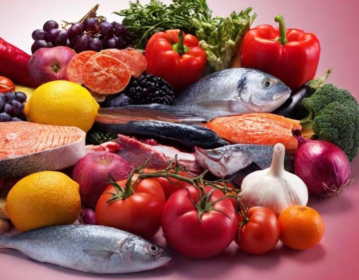 Variedad de frutas, verduras y pescados sobre un fondo azul.